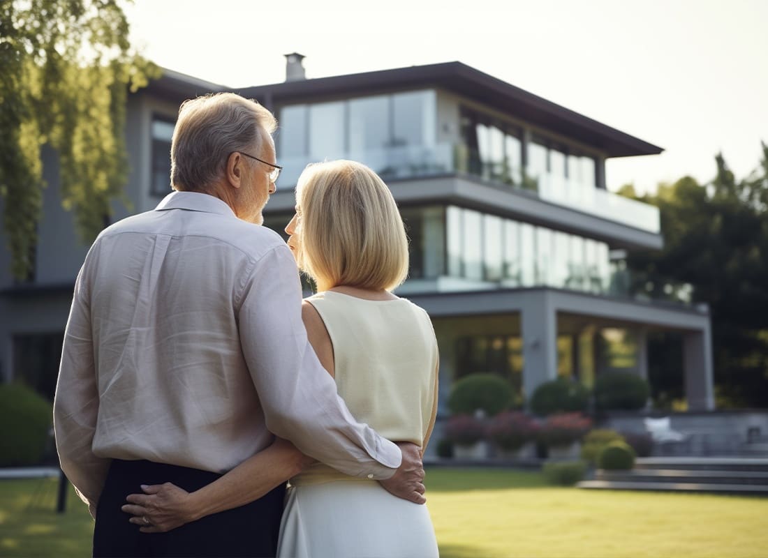 Insurance Solutions - Wealthy Couple Standing in Front of a Home